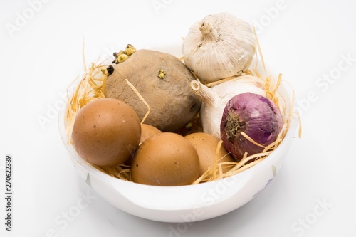 mix of egg potato onion and garlic on the nest with white background.
