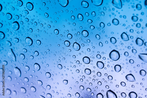 colored raindrops on glass close up