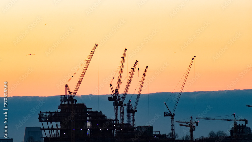Fototapeta premium construction cranes at sunset