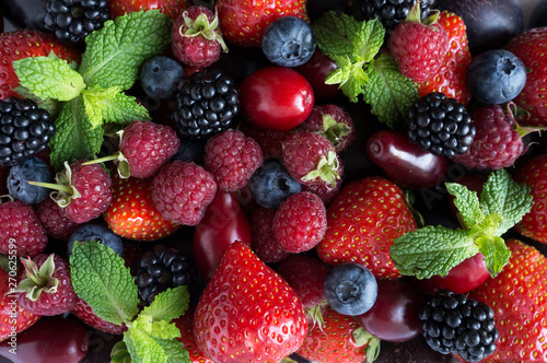 Various fresh summer berries and fruits. Ripe strawberries, raspberries, blackberry; red berries, plum and bleberries. Top view. Red and blue food. Background berries and fruits.