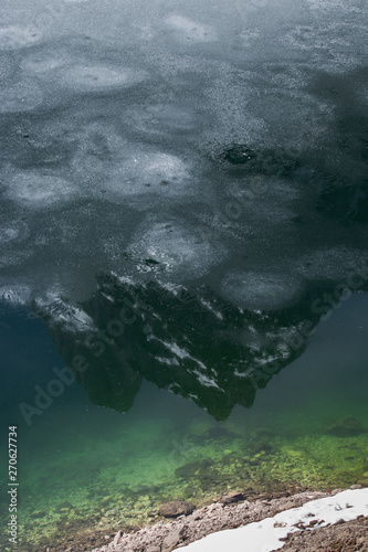 Mountain top reflection in frozen lake