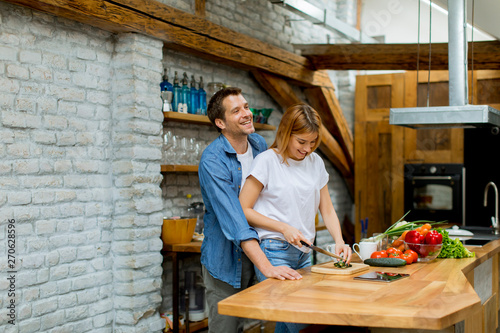 Lovely cheerful couple cook...
