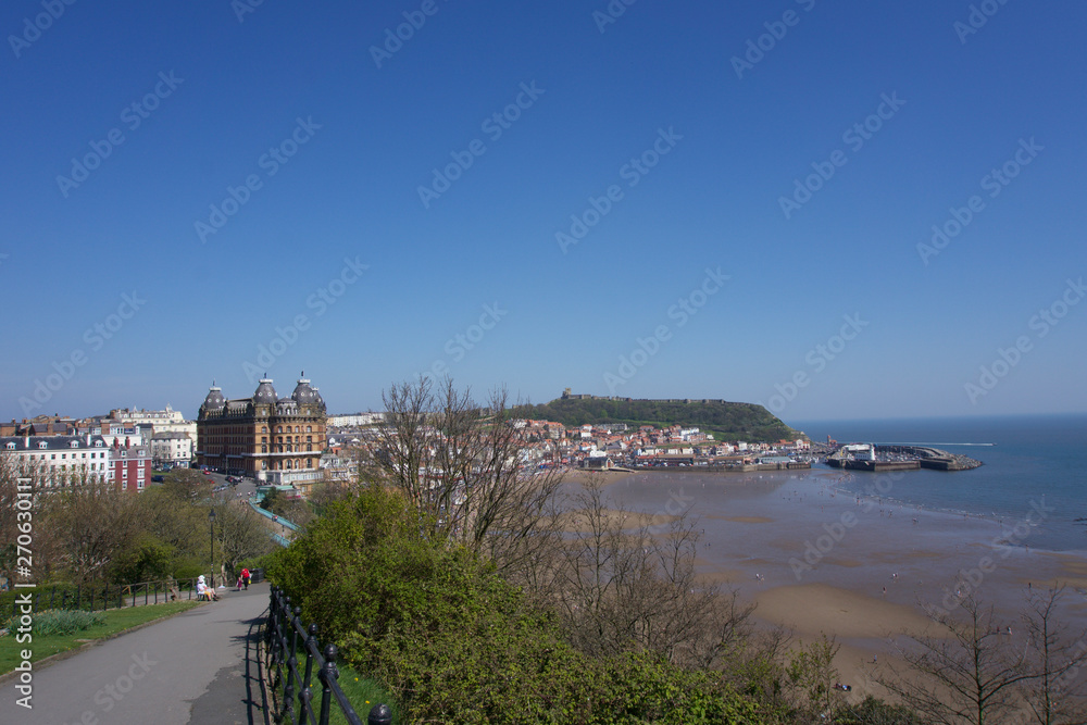 View of castle on hill above town in Scarborough, UK on a clear blue sky sunny day