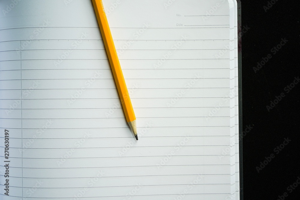 image of a notebooks and pencil on black background, close-up, selective focus image of a notebooks and pencil on black background, close-up, selective focus