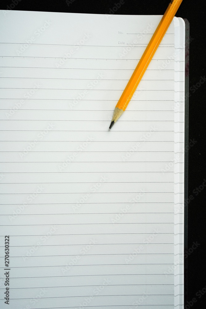 image of a notebooks and pencil on black background, close-up, selective focus image of a notebooks and pencil on black background, close-up, selective focus