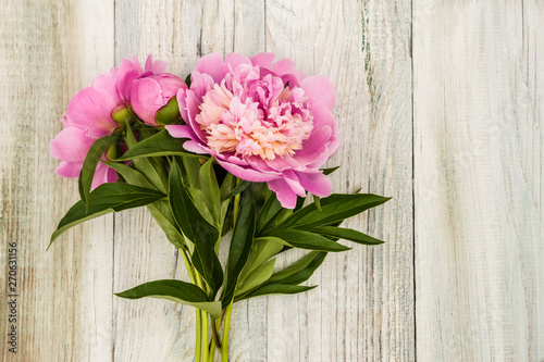 bouquet of pink flowers of peonies on a wooden light background