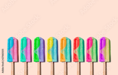 Row of rainbow-colored icecream lollies photo