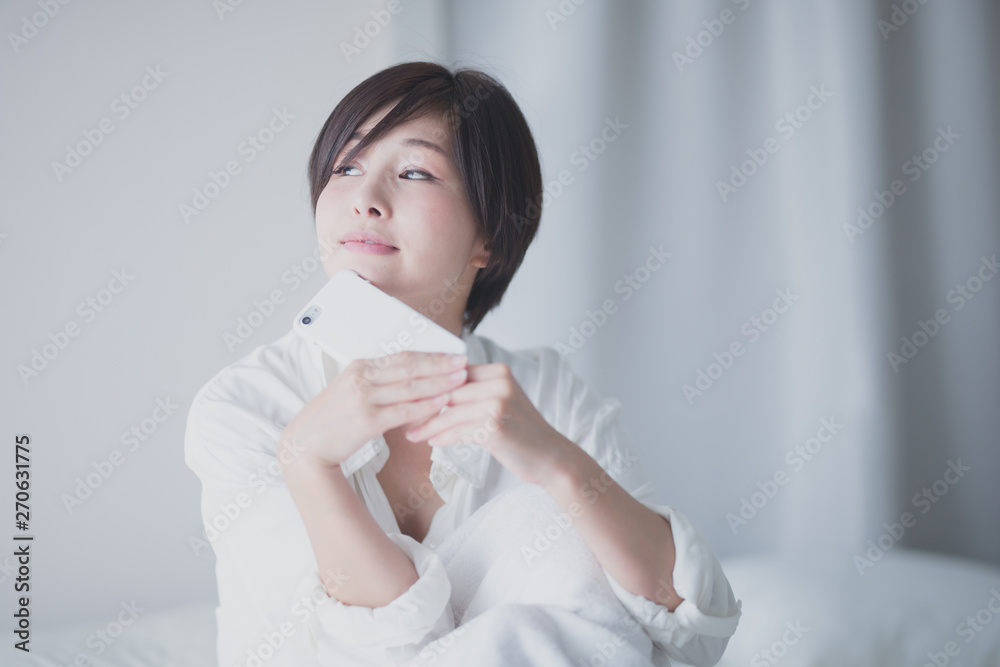 スマホ・女性・ベッド