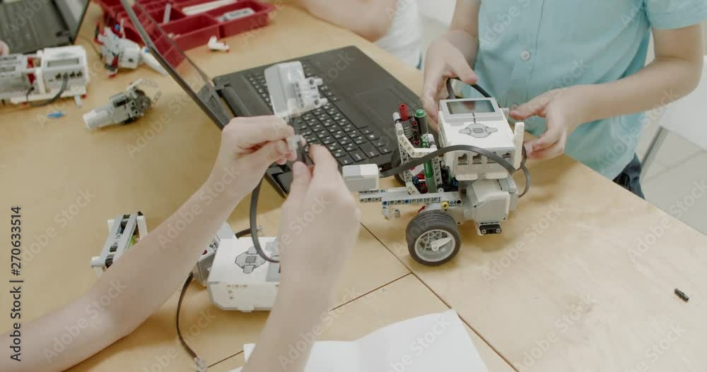 Curious kids working on a functional programable robot during robotics class at school. 4K UHD 60 FPS SLOW MOTION