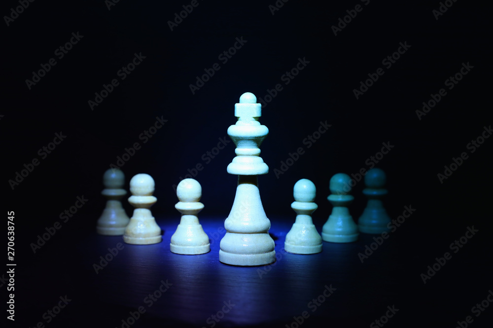 Wooden chess figures under dark and dramatic lighting Wooden chess figures under dark and dramatic lighting