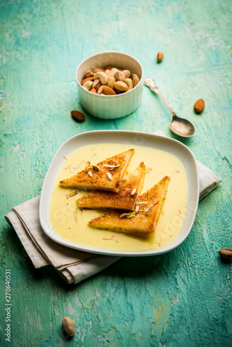 shahi tukra/tukda or Double ka meetha is a bread pudding Indian sweet of fried bread slices soaked in rabid or sweet saffron milk garnished with dry fruits, selective focus