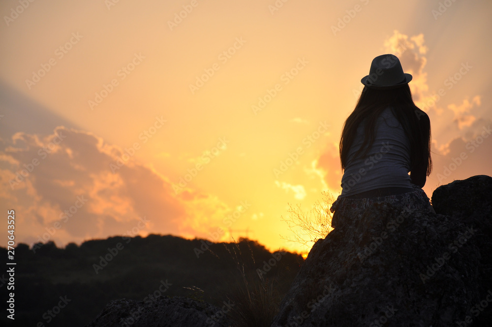 Beautiful woman with hat enjoy in sunset. Woman on top of mountain at sunset