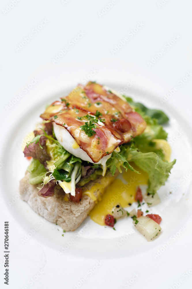 Eggs Benedict with bacon on a white plate Eggs Benedict with bacon on a white plate