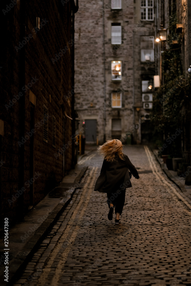 woman running up through a stone street woman running up through a stone street