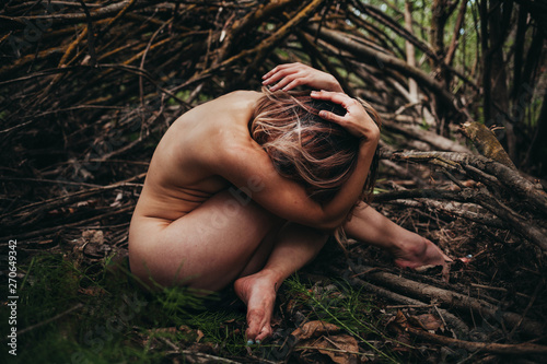 Naked woman sitting outdoors photo