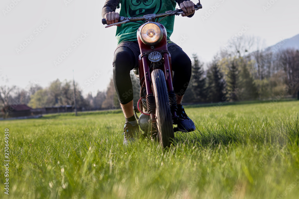 Youth is driving veteran jawa motorbike in the field and grass. Main light lighting in all directions. Lover of motorbikes tries renovated pioneer, fechtl. Pincek. Fichtl. Man has a green t-shirt Youth is driving veteran jawa motorbike in the field and grass. Main light lighting in all directions. Lover of motorbikes tries renovated pioneer, fechtl. Pincek. Fichtl. Man has a green t-shirt