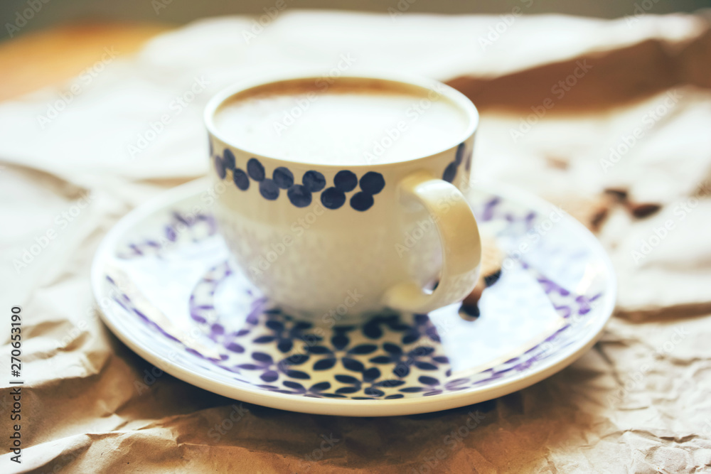 Closeup big mug of morning coffee with milk foam, stylish dishes, still life conceptual in backlight of bright sun Closeup big mug of morning coffee with milk foam, stylish dishes, still life conceptual in backlight of bright sun