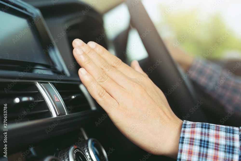 Men use hands to check the air from the ventilation in the car before traveling long distances.