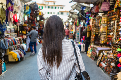 Italy, Florence, back view of young tourist exploring street market photo