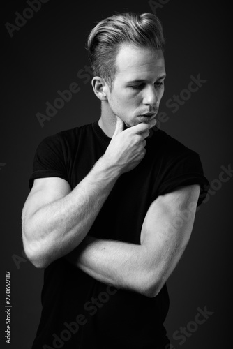 Studio shot of young handsome man against gray background in bla photo