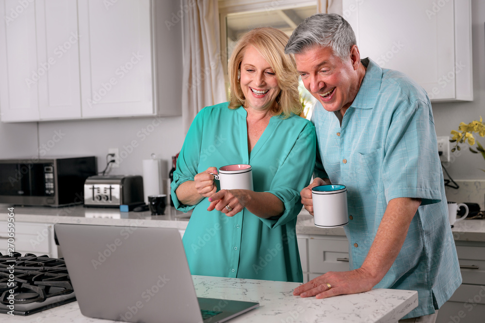Obraz premium Older couple with coffee at home conference call with loved ones on internet web connected computer