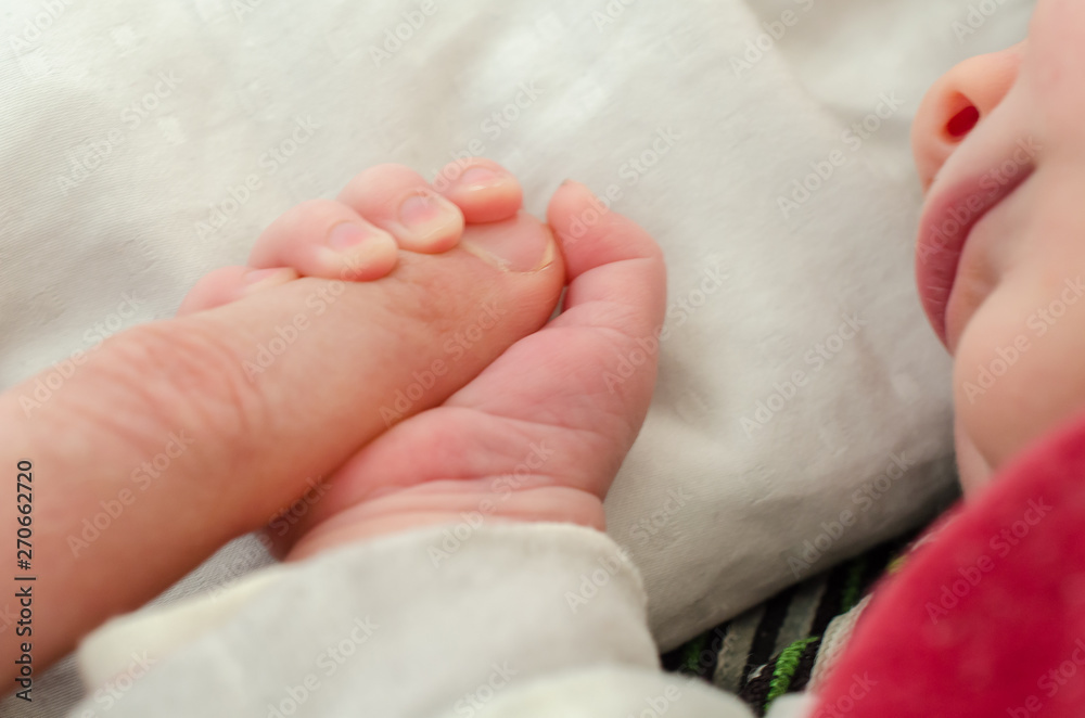 Hand of newborn baby holding male adults finger. Concept of help and family. Father holding hand. Hand of newborn baby holding male adults finger. Concept of help and family. Father holding hand.