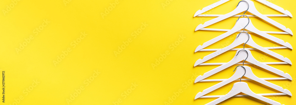 Top view of white clothes hangers on yellow background with copy space.  Flat lay. Minimalism style. Creative layout. Fashion, store sale, shopping  concept. Banner for feminine blog Stock Photo | Adobe Stock