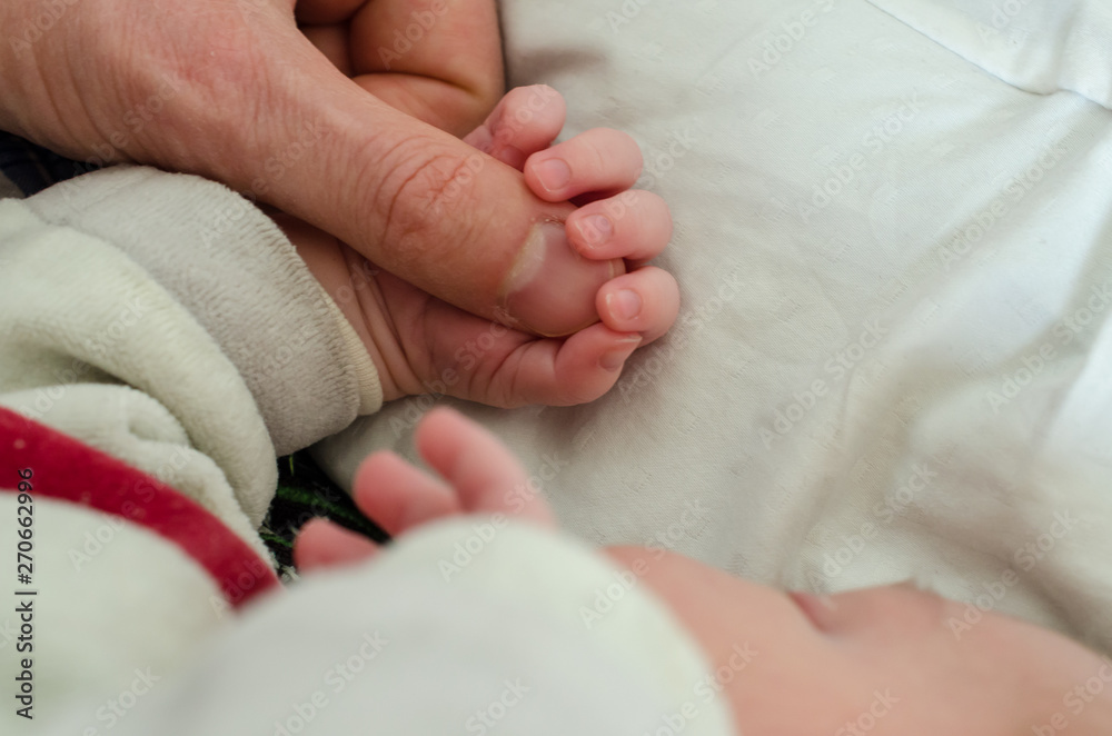 Hand of newborn baby holding male adults finger. Concept of help and family. Father holding hand. Hand of newborn baby holding male adults finger. Concept of help and family. Father holding hand.