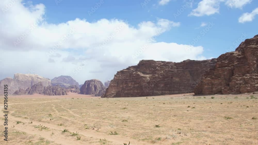 Stone desert landscape, red rocks and sand. Blue sky and white clouds. Stone desert landscape, red rocks and sand. Blue sky and white clouds.