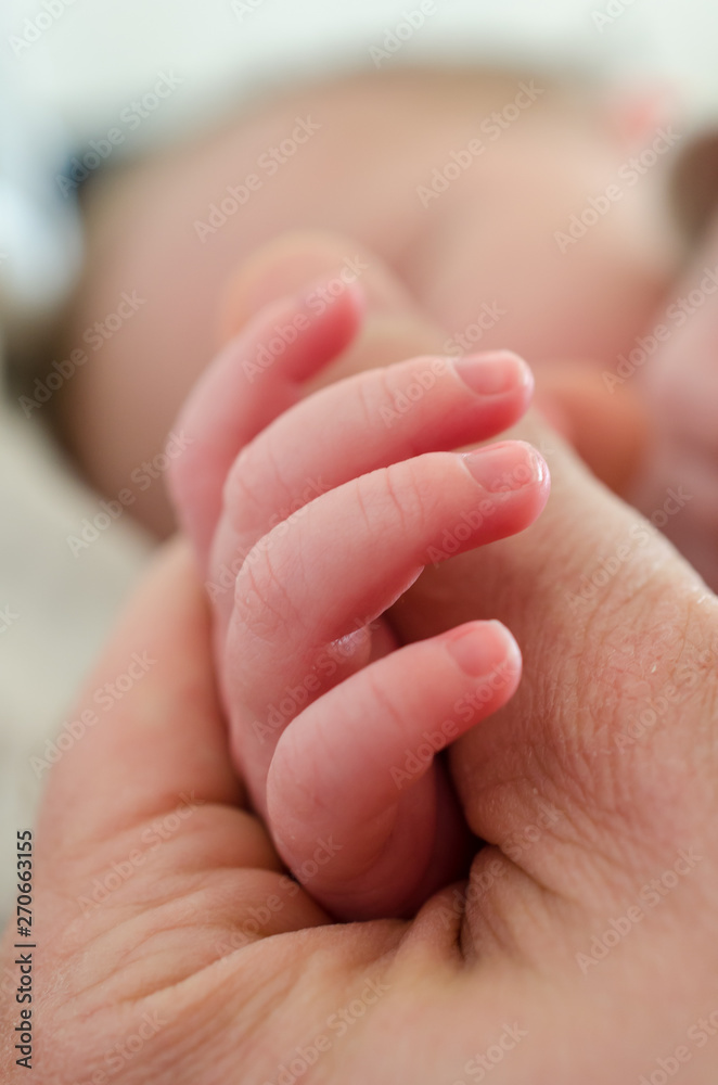 Hand of newborn baby holding male adults finger. Concept of help and family. Father holding hand. Hand of newborn baby holding male adults finger. Concept of help and family. Father holding hand.