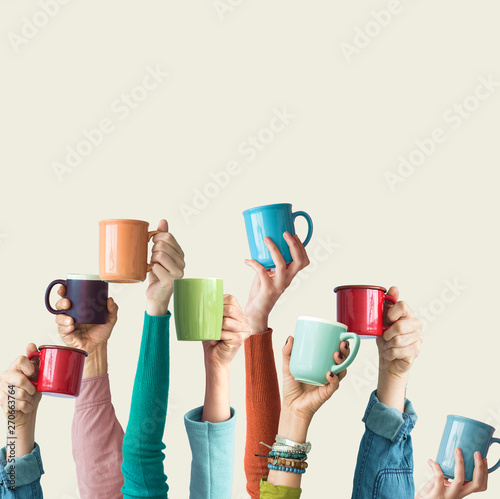 Many different arms raised up holding coffee cup photo