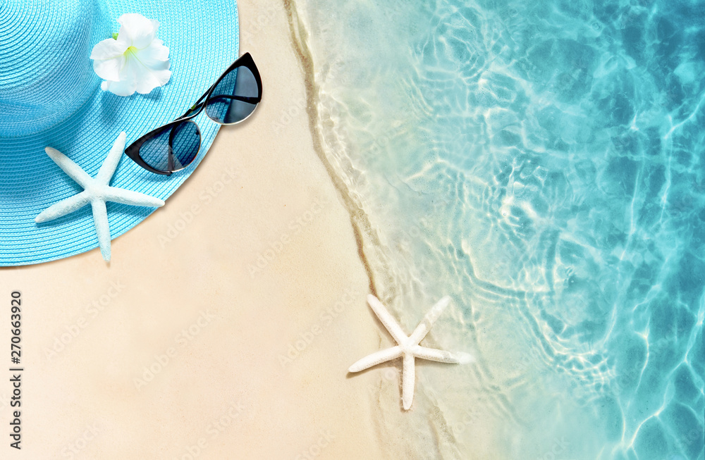 Obraz premium Hat and sunglasses on the sandy beach. Summer background