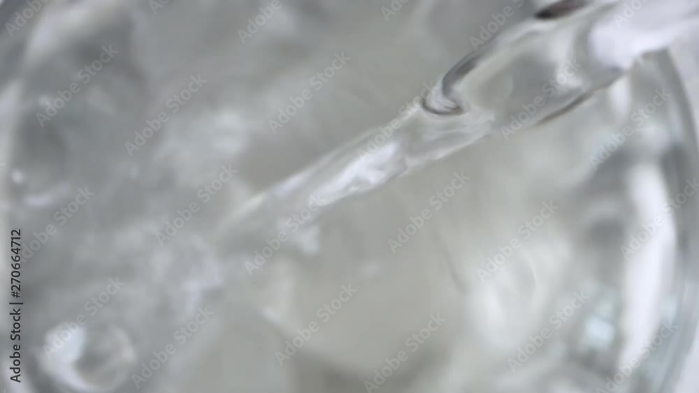 Pouring water into glass close-up, macro. Top view, above Pouring water into glass close-up, macro. Top view, above