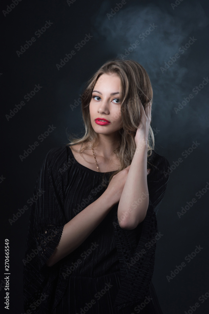 Beautiful ,young blonde with bright red lips and expressive eyes in a black jumpsuit. Beauty portrait of a girl. Emotional and bright appearance. Fashion portrait of a woman. Beautiful ,young blonde with bright red lips and expressive eyes in a black jumpsuit. Beauty portrait of a girl. Emotional and bright appearance. Fashion portrait of a woman.