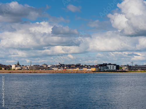 Town landscape, Galway, Ireland, port and Claddagh area, Colorful houses, blue ocean water, cloudy sky.