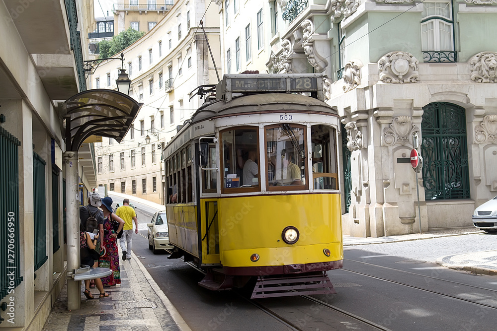 Vintage yellow tramway in the city center of Lisbon. One of the main tourist attractions