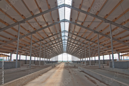 The metal frame of the building on a reinforced concrete base. The use of materials from metal and concrete in modern construction.