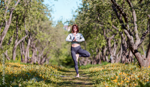 Image of woman standing on one leg in yoga in forest