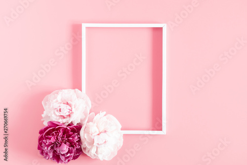 Light pink flowers composition. Blank frame for text, beautiful peonies flowers on pastel pink background. Flat lay, top view, copy space  © prime1001