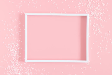 Festive light pink elegant background. Blank photo frame and stars on pastel pink background. Christmas, New Year, birthday concept. Flat lay, top view, copy space 