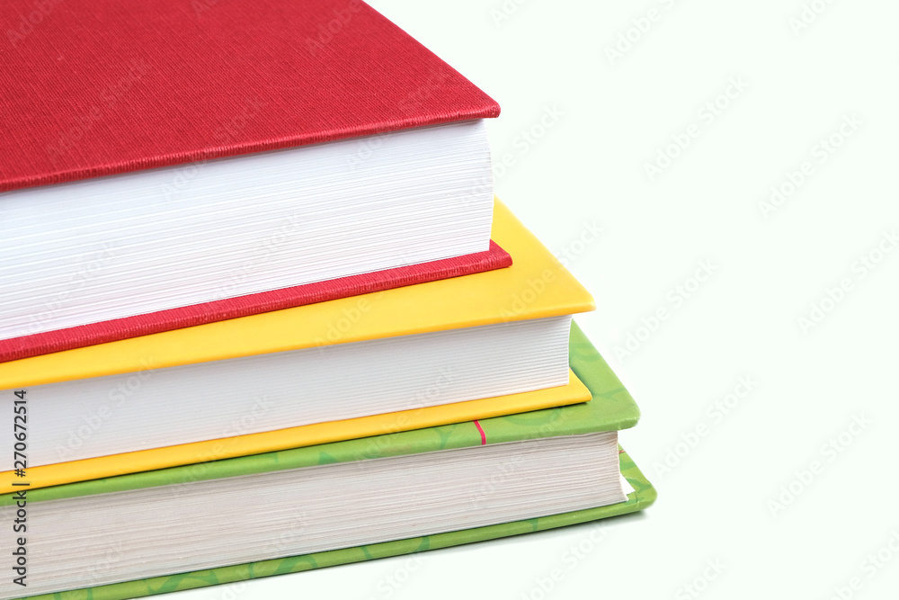 The concept of knowledge, library. Books yellow, red, green on a white background, stacked one on the other. The concept of knowledge, library. Books yellow, red, green on a white background, stacked one on the other.