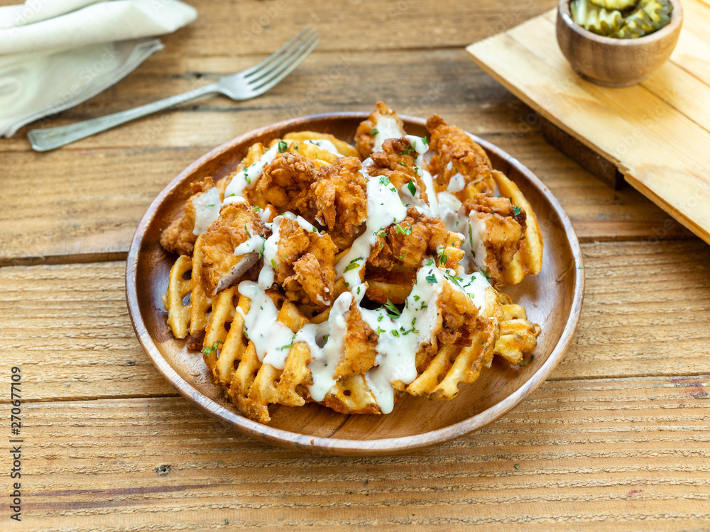 Deep fried waffle fries (french fries), topped with fried chicken nuggets and a thick and creamy country gravy. Deep fried waffle fries (french fries), topped with fried chicken nuggets and a thick and creamy country gravy.