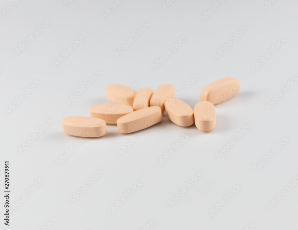 orange long pills capsules of vitamins for health on a white background orange long pills capsules of vitamins for health on a white background