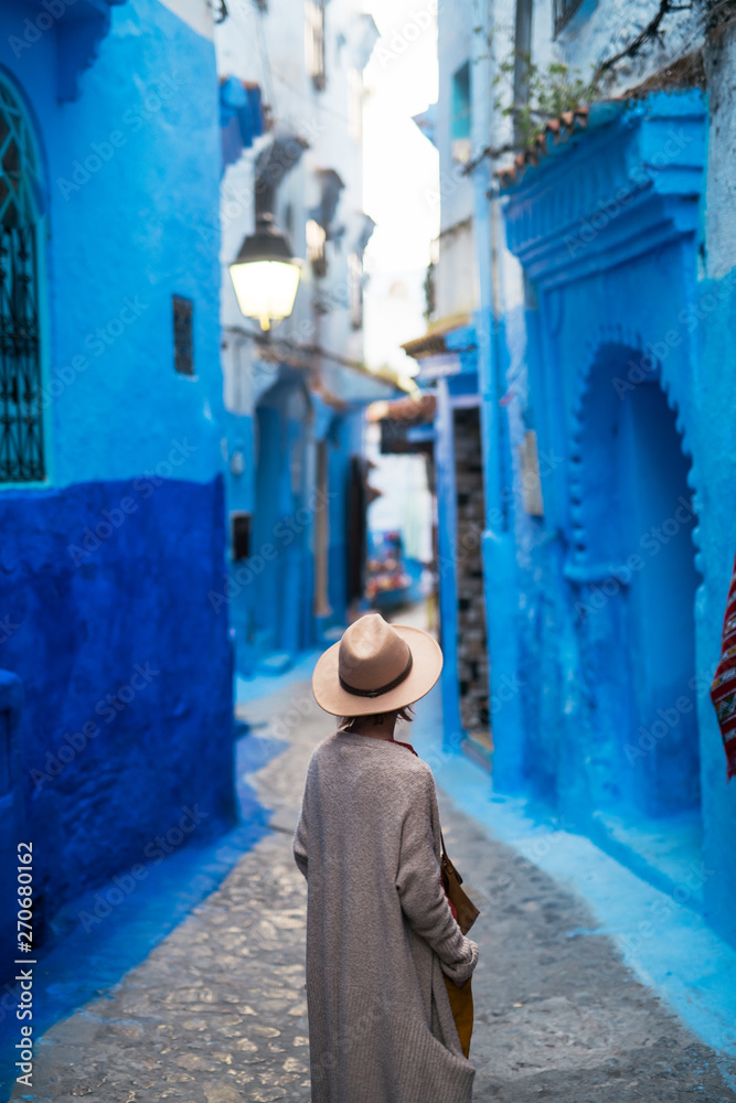 Young woman exploring street an old blue town. Young woman exploring street an old blue town.