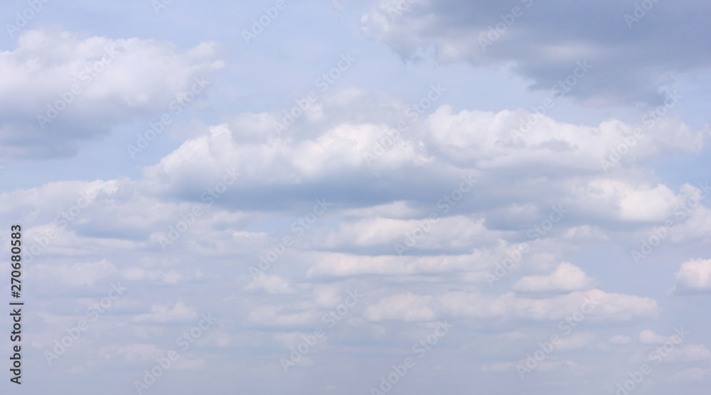 Naklejka premium Puszyste białe chmury na nastrojowym burzowym niebie