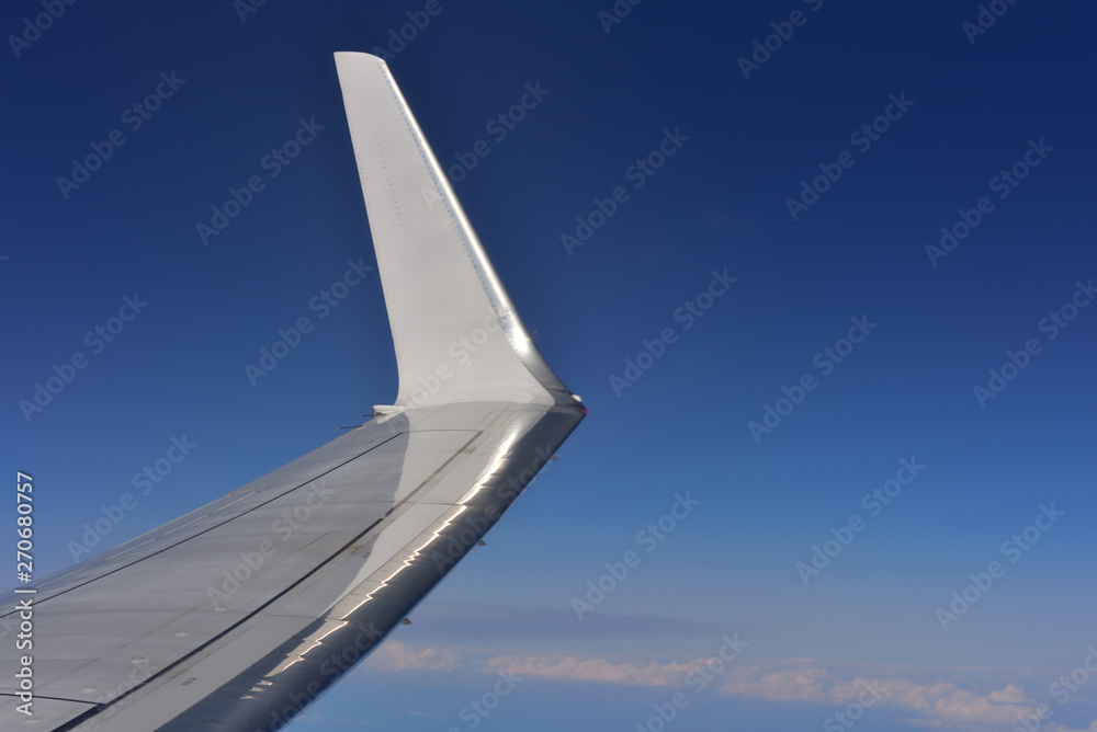 Nahaufnahme eines flugzeugflügels vor blauem himmel Nahaufnahme eines flugzeugflügels vor blauem himmel