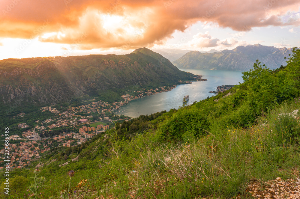 Bay of Kotor from the heights. View from Mount Lovcen to the bay. View down from the observation platform on the mountain Lovcen. Mountains and bay in Montenegro. The liner near the old town of Kotor. Bay of Kotor from the heights. View from Mount Lovcen to the bay. View down from the observation platform on the mountain Lovcen. Mountains and bay in Montenegro. The liner near the old town of Kotor.