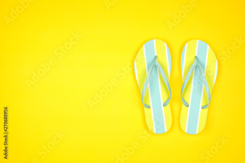 Summer flip flops on a yellow background. Summer vacation concept. Top view with copy space.