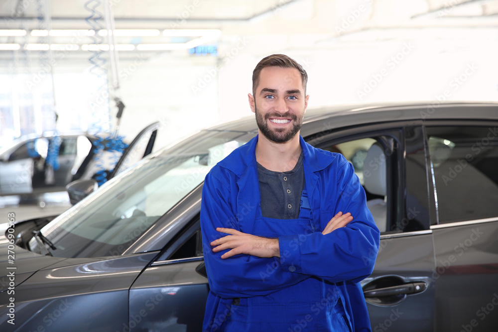 Portrait of worker standing near automobile at car wash Portrait of worker standing near automobile at car wash
