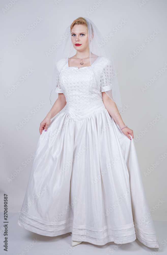 pretty curvy adult woman with short hair wearing long vintage wedding dress with sun style skirt. young caucasian bride with veil on white studio background alone. pretty curvy adult woman with short hair wearing long vintage wedding dress with sun style skirt. young caucasian bride with veil on white studio background alone.